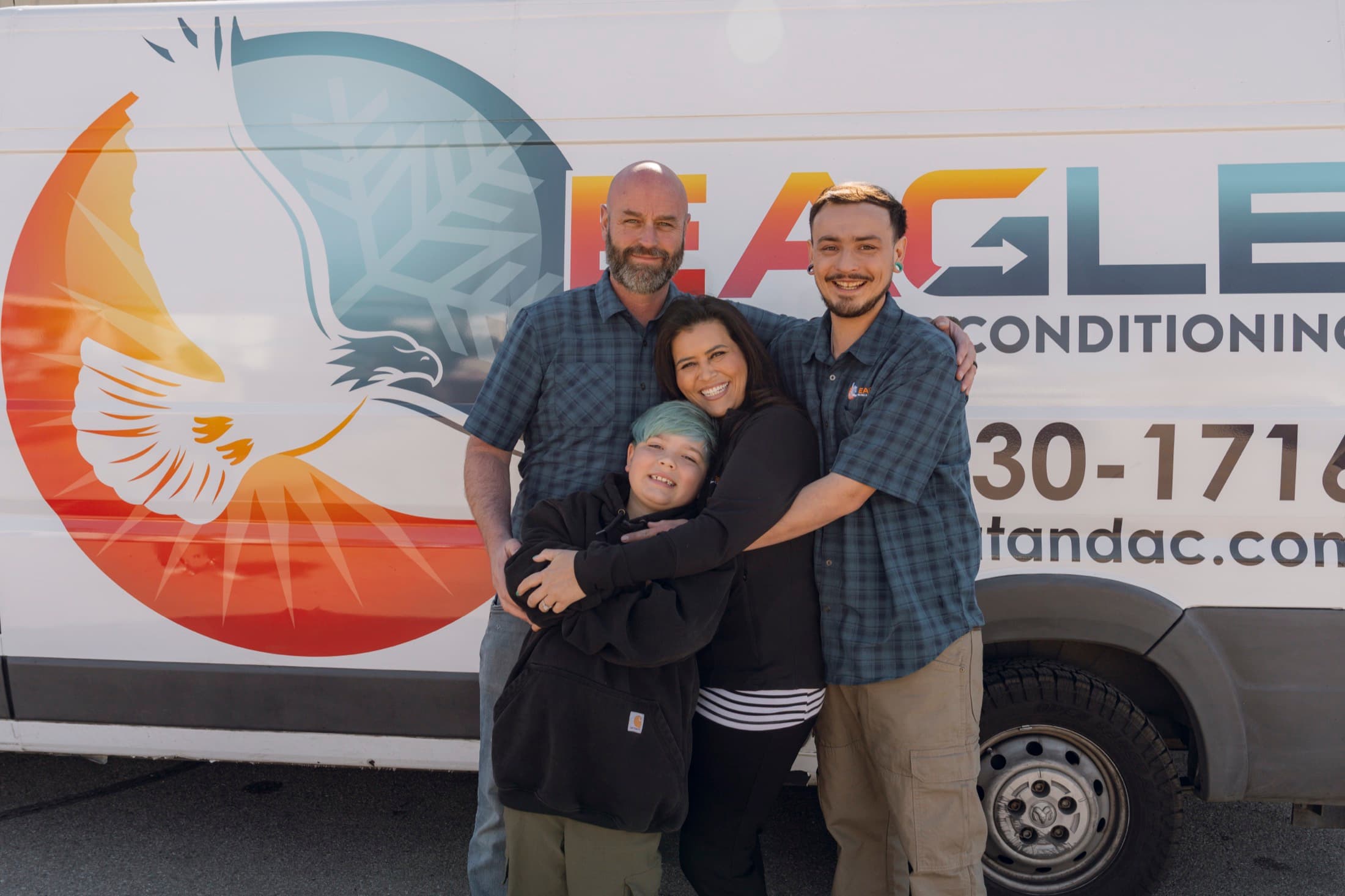 Eagle Heating and Air team standing with branded service van