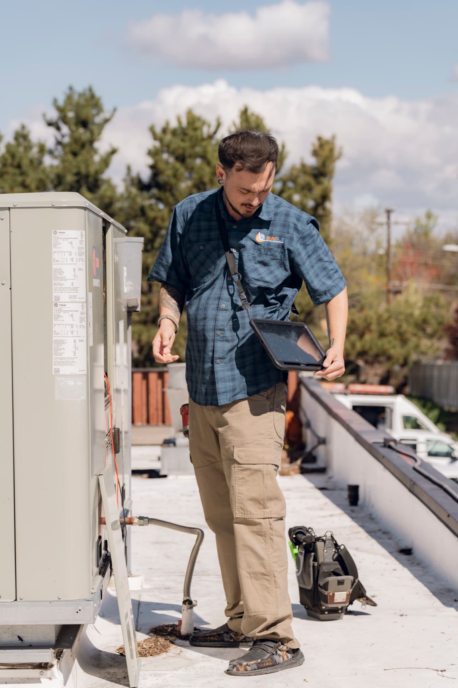 Eagle Heating and Air technician inspecting a commercial rooftop HVAC unit