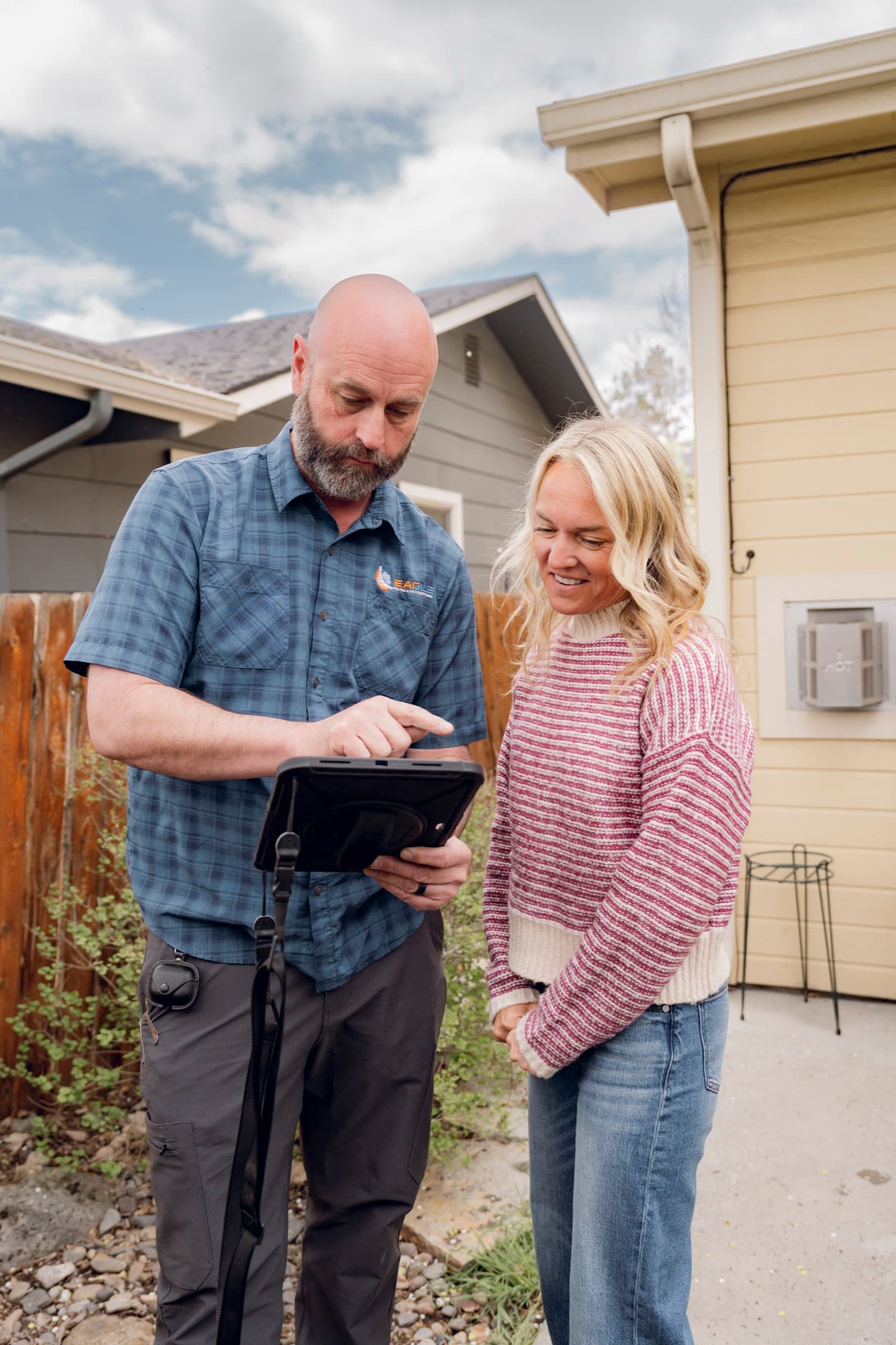 Eagle Heating and Air technician reviewing AC service with a homeowner